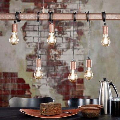EGLO Townshend 4 langbordspendel i rustfarvet metal med seks synlige lyskilder og kobberdetaljer, monteret over et spisebord.
