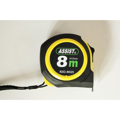 Nærbillede af Tajima Trading båndmål 8m 25mm, fremhæver ASSIST logoet og den sorte og gule farvekombination på huset.