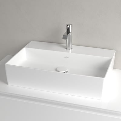 Overbliksbillede af Villeroy & Boch Memento 2.0 surface håndvask i hvid porcelæn med vandhane og afløb på hvidt møbel.