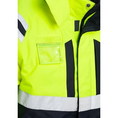 Nærbillede af Fristads HI Vis AIRTECH® vinterkedeldragt i gul og marineblå, med synlig ID-kortlomme og reflekterende bånd.