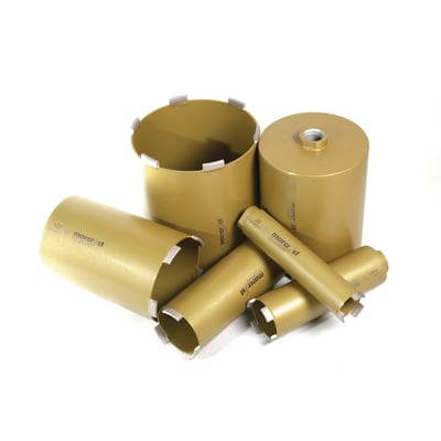 En samling af Baier diamantbor i gylden messingfarve, inklusive et større bor og mindre forlængere.