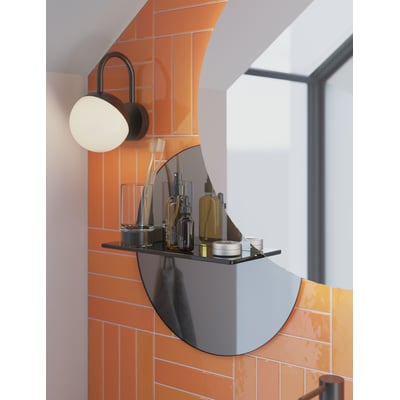 Dansani Bright lampe i sort mat monteret på en væg med orange fliser og et rundt spejl.