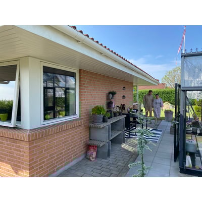 Hvid Plastmo tagrende på 3 meter monteret på en murstensvilla med to personer gående på terrassen.