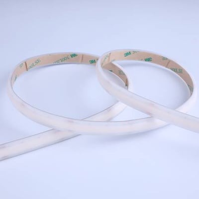 Ansell Lighting C-Cell COB TW LED strip på 5 meter med 3M tape på bagsiden, vist i et krydset arrangement mod en lyseblå baggrund.