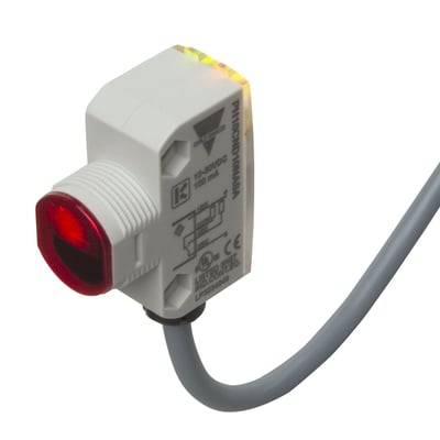 Carlo Gavazzi fotoaftaster PH18CNT20 med hvidt kvadratisk hus, M18-gevind, rød frontlinse og gråt kabel.