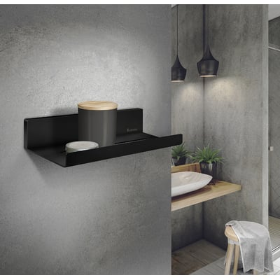 Smedbo Sideline brusehylde i mat sort, 250 x 112 mm, monteret på en grå betonvæg med opbevaringsgenstande.