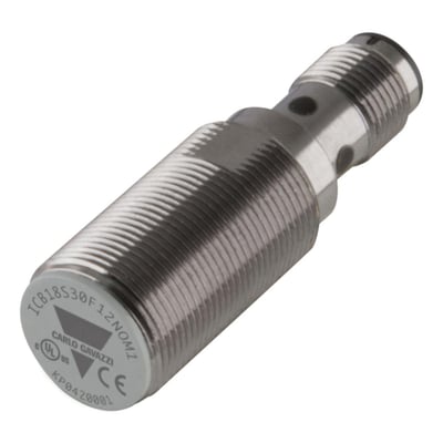 Kort induktiv M18-sensor fra Carlo Gavazzi med gevindskåret metalhus, PNP NO og 12 mm detekteringsafstand.