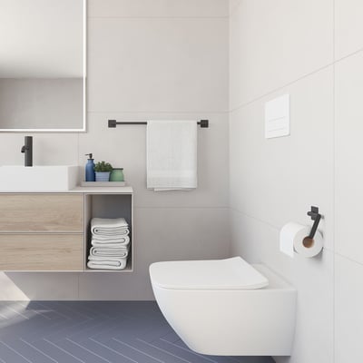 Smedbo Cube enkel håndklædestang i mat sort, monteret på en badeværelsesvæg over en toiletkumme med håndklæder.