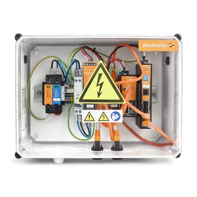 Weidmüller combiner box til solcellesystemer med synlige elektriske komponenter og kabler bag et gennemsigtigt låg.