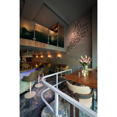 SLV LISENNE væglamper i stengrå lyser op på væggen i en moderne restaurant.