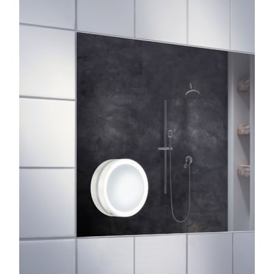 Smedbo Outline Lite sminkespejl med sugekopper, 7x forstørrelse, hvidt og rundt med lys monteret på en badeværelsesvæg.