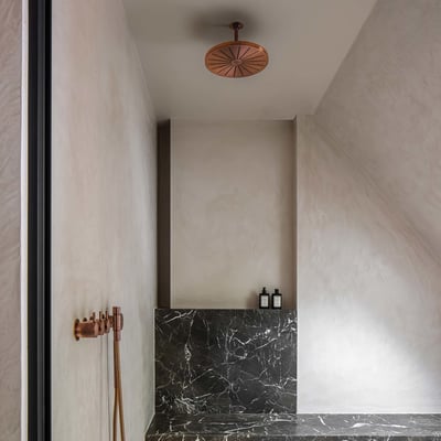 Vola indbygningstermostat i kobber med tre greb og ¾'' tilslutning i et moderne badeværelse med marmor.