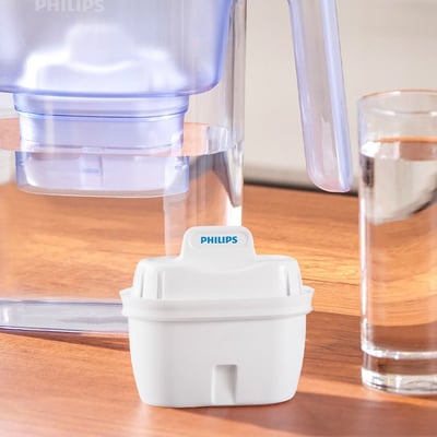 Et hvidt Philips vandkandefilter, model AWP230P6/31, placeret foran en vandkande og et glas med vand.
