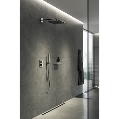 Grohe Grohtherm Cube brusesystem installeret i et moderne badeværelse med grå stenfliser og glasvæg.