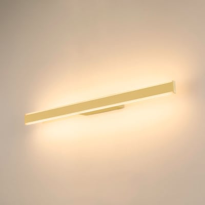 SLV One Linear 70 væglampe, mat hvid og mat messing, lyser varmt hvidt lys på en lys væg.