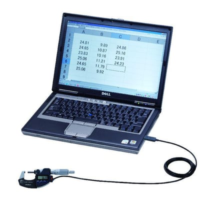 Digital mikrometer med USB-kabel forbundet til en Dell bærbar computer, der viser data i et regneark.