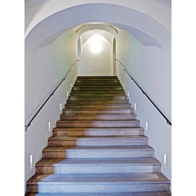 Astro Borgo 35 Trimless LED væglampe, hvid, monteret diskret på en trappeafsats for at oplyse trinene.