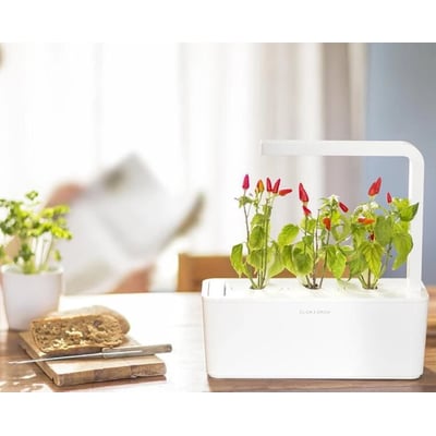 Click & Grow smart have med fuldt udvoksede chiliplanter, der bærer mange røde og grønne chilier.