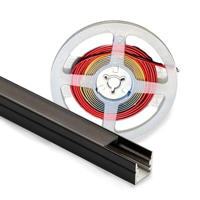 Nærbillede af en sort aluminiumsprofil til LED lys og en rullet LED strip på en metalspole, isoleret på hvid baggrund.