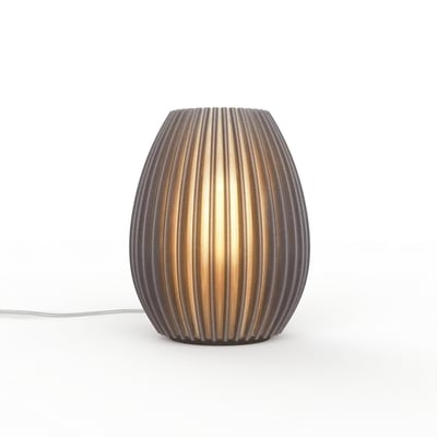 myCreation Jagg Two bordlampe i mørkegrå med en ribbet struktur og varm, gul lyskilde, placeret på en hvid baggrund med ledning synlig.