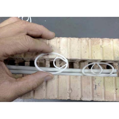 Fclip rørholder i hvid plast bruges til at fastgøre rør op til 60mm i en murstensrille.