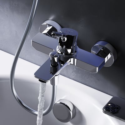 AM.PM X-Joy S kararmatur i krom, der løber med vand på en hvid badekar og mørk væg.