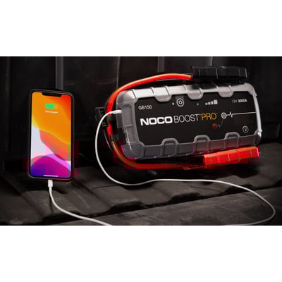 Noco Genius GB150 Boost Pro jumpstarter til 12V batterier oplader en iPhone, der viser 88% opladet. Begge er forbundet med hvide kabler.