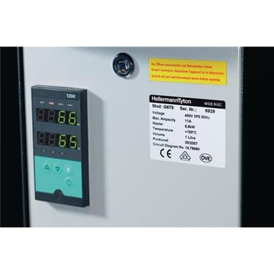 HellermannTyton komponentlabel i sølvfarve på en grå panel med et digitalt display og advarselsetiket på dansk og fransk.