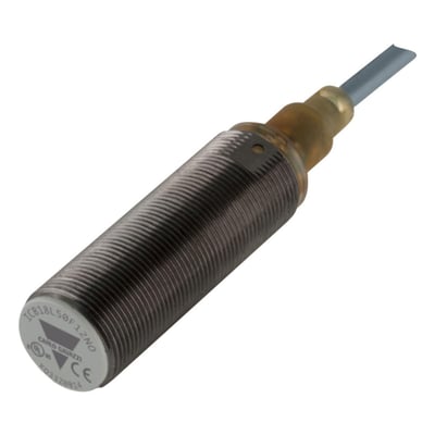 Carlo Gavazzi M18-induktiv sensor med mørkt gevindhus og kabel, vist skråt forfra; PNP NC-model med 12 mm detekteringsafstand.