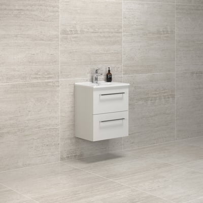 Dansani Mido+ møbelpakke, 51 cm, hvid mat vaskeskab med to skuffer og kromgreb, monteret på væg med lysgrå klinker som baggrund.