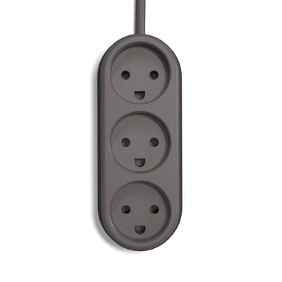 Nærbillede af ColorCable Experimental stikdåsens tre udtag på en mørkegrå baggrund, med et smilende ansigt motiv.