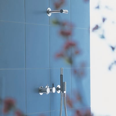 Vola 1-grebsblander med keramisk ventilenhed monteret på blå fliser, vist med en brusehoved holder ovenfor.