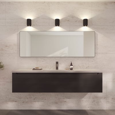 Loevschall Refine spejl med en slank, bruneret messingramme, 55x160 cm, monteret over et mørkt væghængt badeværelsesskab.