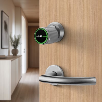 Zafe smart-cylinder OVAL med app monteret på en trædør med sølvfarvet greb og sort front med grøn ring.