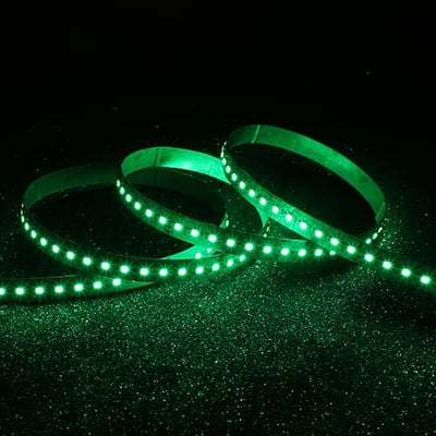 Ansell Lighting P-Cell RGBW LED bånd i grøn belysning, der snor sig mod en mørk, glitrende baggrund.