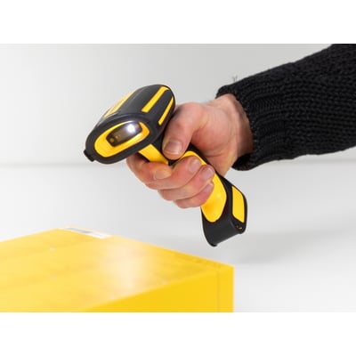 DeLock industriel stregkodescanner i gul og sort holder over en gul pakke, klar til scanning.