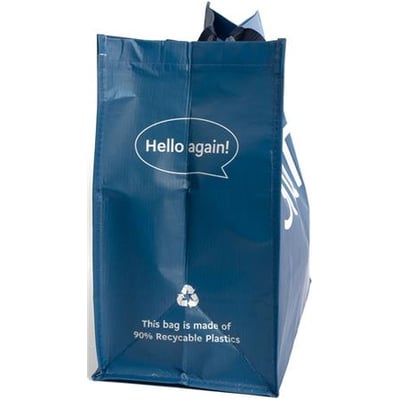 Blå indkøbstaske af 90% genanvendt plastik med teksten "Hello again!" og genbrugssymbol.