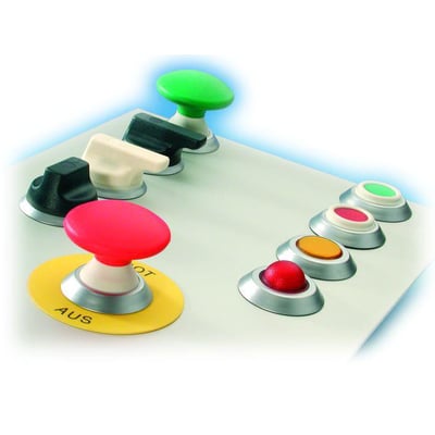 Forskellige drejegreb og trykknapper i flere farver og former, monteret på en grå kontrolpaneloverflade.