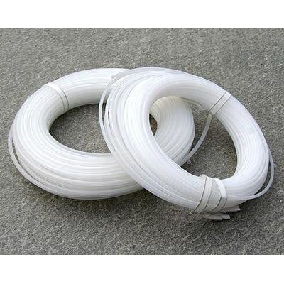 CommScope FOPT fiberoptisk transportrør i transparent materiale, Ø3,1mm, præsenteret på ruller på en grå stenoverflade.