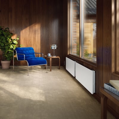 Ebeco Wallflex el-radiator 600 WiFi, 1500W, 230V, hvid, monteret ved et stort vindue i et hyggeligt rum.