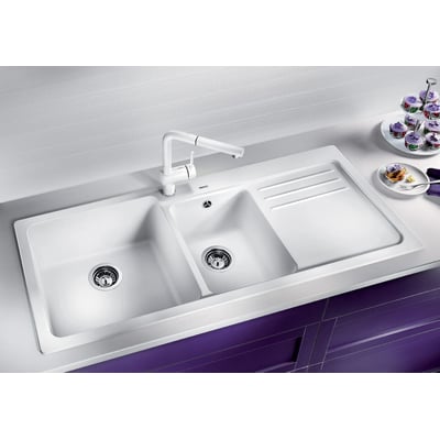 Blanco Naya 8 S UX køkkenvask i hvid komposit, 116x50 cm, med to kummer, hane og integreret afløbsbakke monteret i en hvid bordplade.