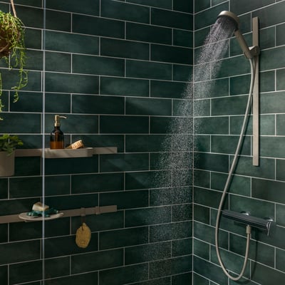 Hansgrohe kroge monteret i et moderne badeværelse med mørkegrønne vægfliser, viser opbevaring af sæbe og børster.