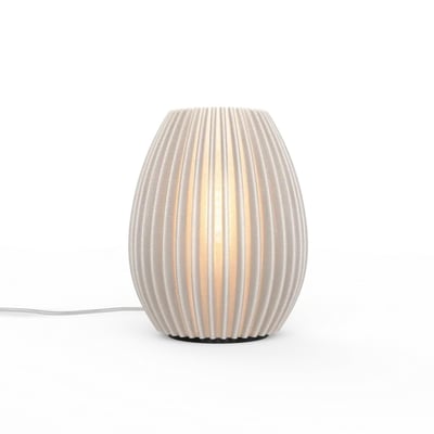 myCreation Jagg Two bordlampe i transparent hvid med unik ribbet struktur, der skaber en varm lyseffekt på hvid baggrund.