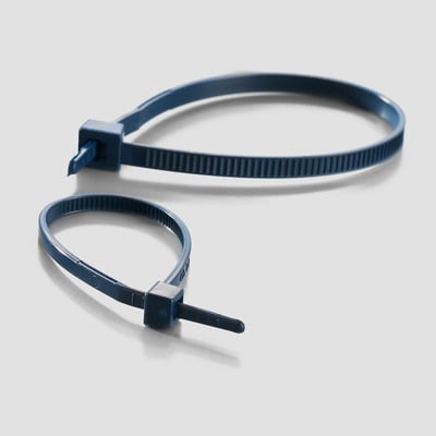 Nærbillede af to blå Weidmüller CB-DT kabelbindere, viser tænderne på den store og låsemekanismen på den lille.