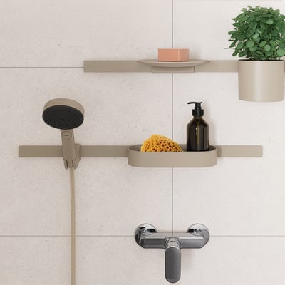Hansgrohe brusehylder i beige mat, viser monterede hylder med sæbe, plante, svamp og sæbedispenser i et moderne badeværelsesmiljø.