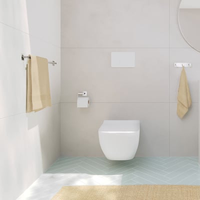 Smedbo Cube toiletpapirholder monteret på væggen i et moderne badeværelse med toilet og håndklæder.