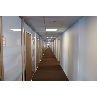 SG Armaturen Sense Pro Connect LED panel installeret i en kontorgang. Panelet er monteret i loftet over den brune gulvtæppe.