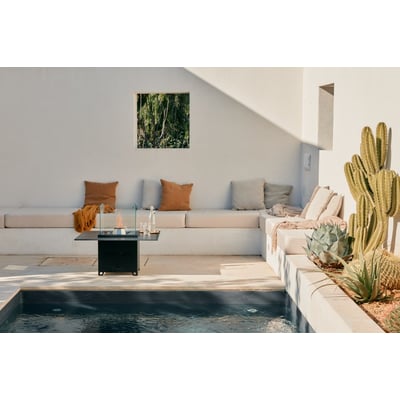 Pelmondo Cube terrassepejs i sort stål med en glasafskærmning, placeret ved siden af en swimmingpool.