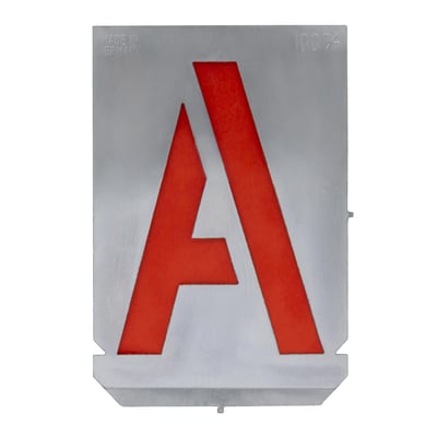 Ét stencil med bogstavet A, 100mm tegnhøjde, fremstillet af 0,3 mm tykt zinkark i sølvfarve med røde bogstavsudskæringer.