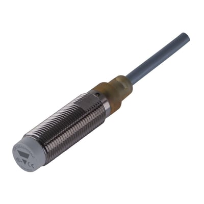 Carlo Gavazzi induktivaftaster M12 med forniklet messinghus, grå front og kabel, set skråt.